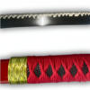 Gros plan sur la lame du katana Sandai Kitetsu avec son motif ondulé distinctif et le manche recouvert d'une tresse rouge avec détails dorés.