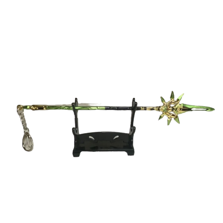 Mini réplique de la Lance de Jade Ailé inspirée de Genshin Impact, posée sur un support noir. La lance arbore un design doré et vert, avec une pointe détaillée rappelant des ailes stylisées. Une chaîne métallique est attachée à l'extrémité, faisant de cette réplique un porte-clés ou un objet de collection raffiné.